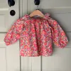 PDF sewing pattern downloadable for baby blouse with raglan sleeves and ruffled collar